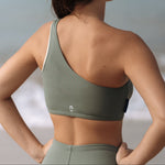 Woman wearing Ninefoot Studio Kongs one shoulder surf top in army green – asymmetric cut Italian recycled fabric bikini top designed for movement in Bali