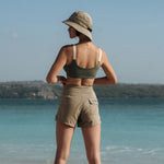 Woman wearing Ninefoot Studio army green surf shorts with contrast stitching – mid-rise tailored fit quick-dry deadstock polyester twill ethically made in Bali