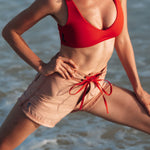Woman wearing Ninefoot Studio pink surf shorts with contrast stitching – mid-rise tailored fit quick-dry deadstock polyester twill ethically made in Bali