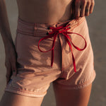 Woman wearing Ninefoot Studio pink surf shorts with contrast stitching – mid-rise tailored fit quick-dry deadstock polyester twill ethically made in Bali