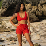 Woman wearing Ninefoot Studio red surf shorts with contrast stitching – mid-rise tailored fit quick-dry deadstock polyester twill ethically made in Bali