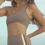Woman wearing Ninefoot Studio Kongs one shoulder surf top – asymmetric cut Italian recycled fabric bikini top designed for movement in Bali