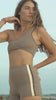 Woman wearing Ninefoot Studio Kongs one shoulder surf top – asymmetric cut Italian recycled fabric bikini top designed for movement in Bali